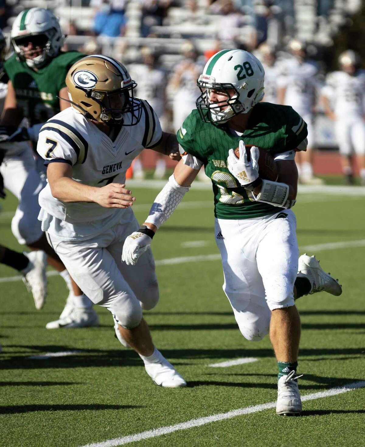 The Woodlands Christian Academy running back Ryan Leslie (28) rushes passed Boerne Geneva defensive end Jayden McCammon (7) during the first quarter of a TAPPS Division II bi-district game at Warrior Stadium in The Woodlands, Saturday, Nov. 21, 2020.
