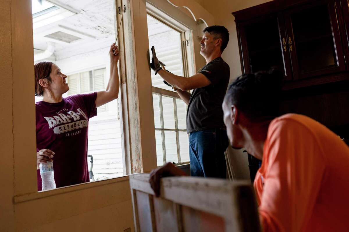 From left, Lisa Turner, Kevin Gremillion, and Donovan Harris, foreground, work on repairing a window in the Bungalow Colony in the Kelly Field Historic District in San Antonio, TX, on Aug. 23, 2022. The city's Office of Historic Preservation is working with Port San Antonio to restore the 15 large, 1920s bungalow houses, once used as officers' quarters. The work starts with repairs to the houses' distinctive windows through the city's Living Trades Academy, in classes taught by window expert Steve Quillian.