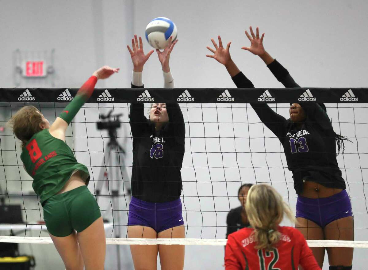 Fulshear's Rachel Nordt (16) gets her hand on the ball to block a shot by The Woodlands' Makenzie Weddel (8) beside Fulshear's Olivia Drayden (13) in the first set of a non-district high school volleyball match during the Adidas John Turner Classic, Friday, Aug. 12, 2022, in Webster.