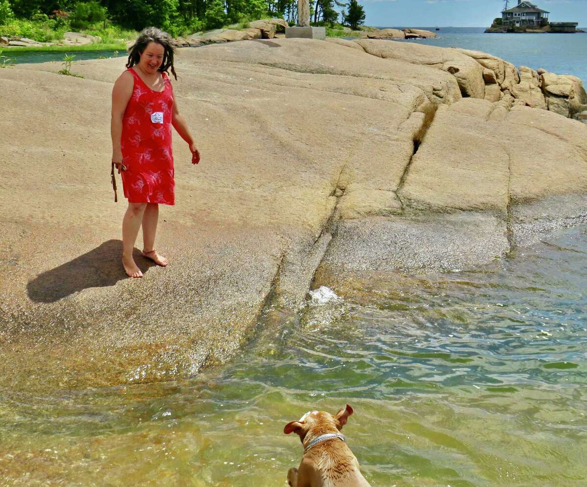 Army veteran Michelle Mullin with her dog Rocksha at a recent Take A Vet Fishing outing at Killam’s Point in Branford.