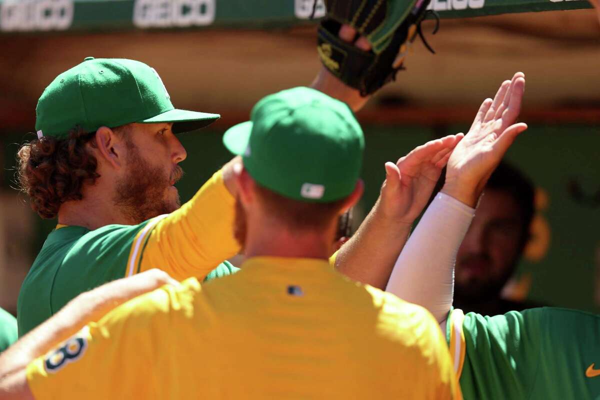 OAKLAND, CALIFORNIA - AUGUST 24: Cole Irvin #19 of the Oakland Athletics is congratulated by teammates when he comes back to the dugout after the seventh inning at RingCentral Coliseum on August 24, 2022 in Oakland, California. (Photo by Ezra Shaw/Getty Images)