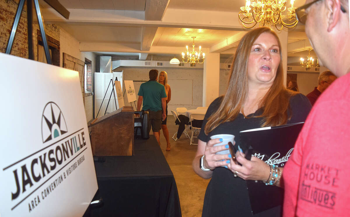 Brittany Henry, executive director of the Jacksonville Area Convention & Visitors Bureau, visits with Court Hager after five Jacksonville organizations unveiled a unified brand identity and logo Wednesday.