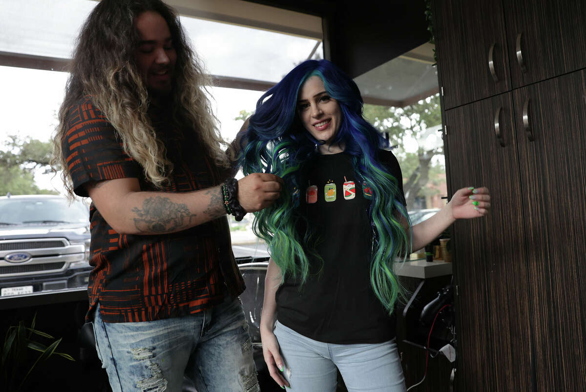 Patrick Garcia, a hair stylist who specializes in colorful, high-end hair extensions, works on his client, Maggie Whitten, at his salon. Whitten's extensions are real human hair that's been dyed and curled.