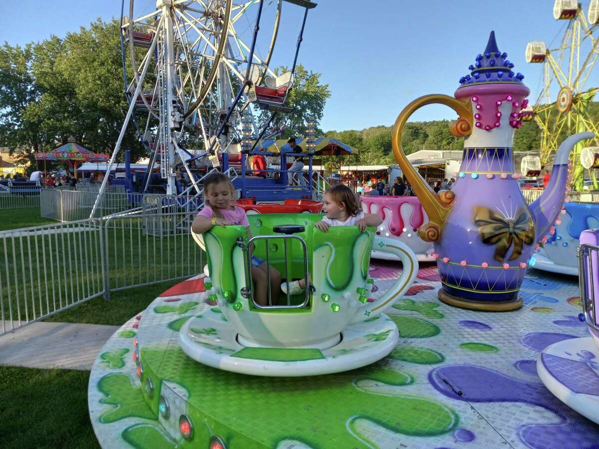 Olivia and Lucy Melycher ride the spinning teacups at the Winsted Fire Department’s annual carnival at Rowley Field.