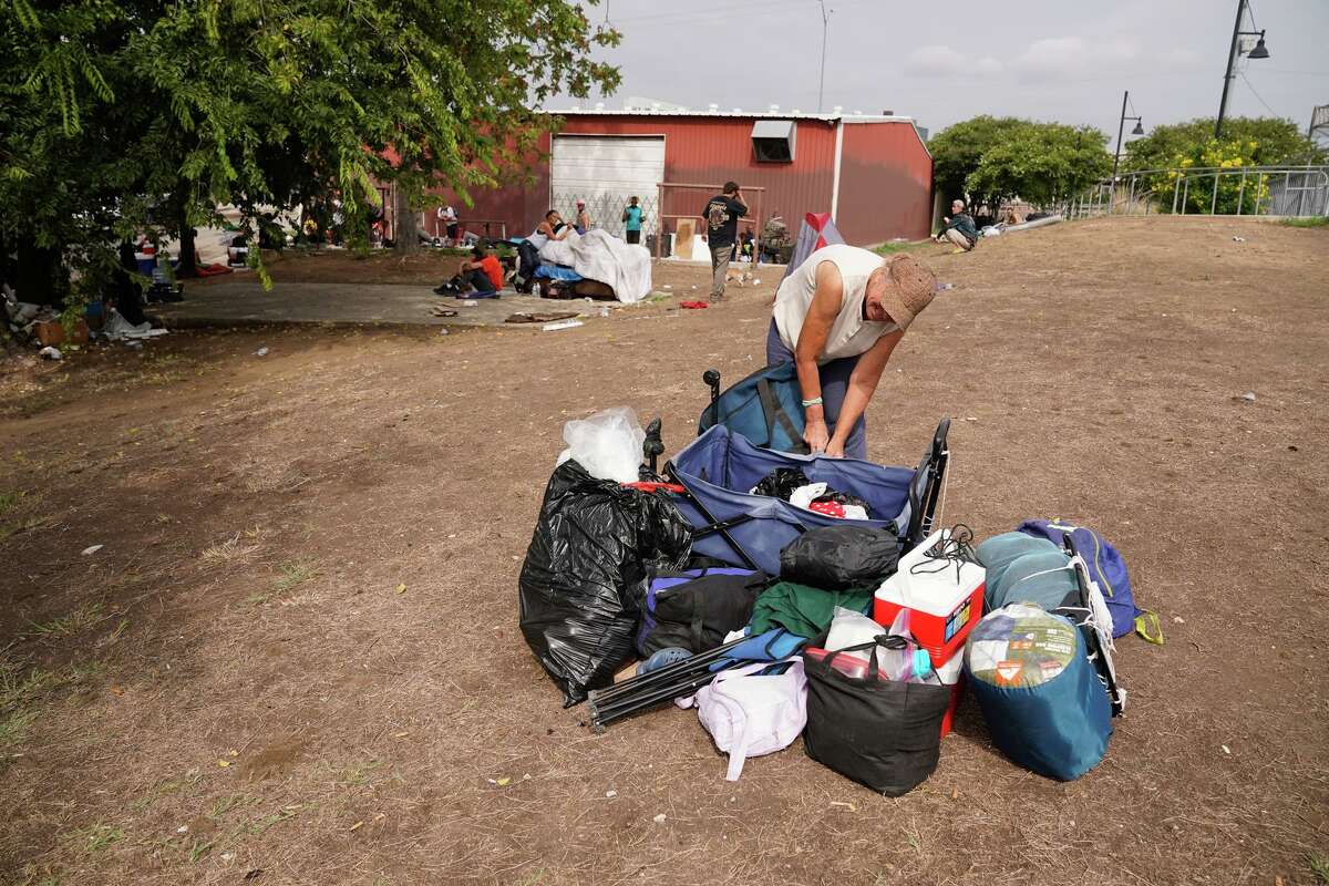 Lynn Diehl lays her belongings in a lot on Hays Street as she and other homeless people were removed from underneath Interstate 37 at Brooklyn Avenue on Thursday morning.