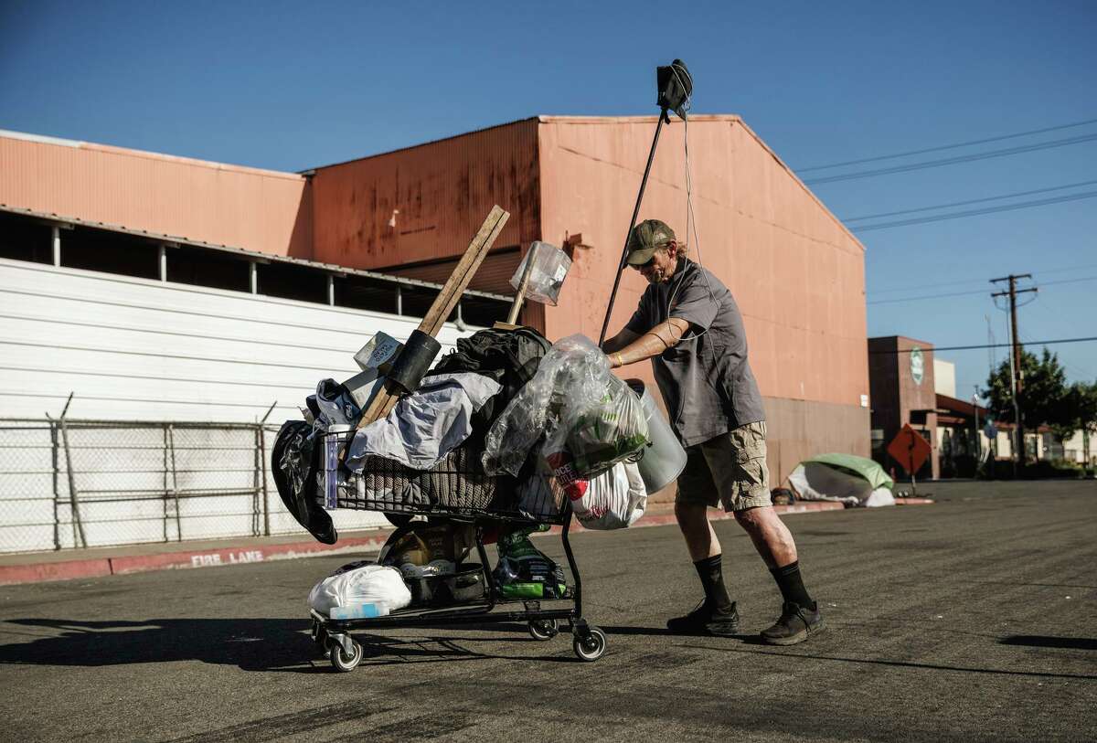 2022年8月24日，星期三，加州萨克拉门托，52岁的拉里·罗伯特·韦尔奇推着一辆手推车。根据选民将在11月考虑的一项全市范围的投票措施，如果该市和县建造了最低数量的新避难所，无家可归者可能会合法地被迫离开他们的营地。