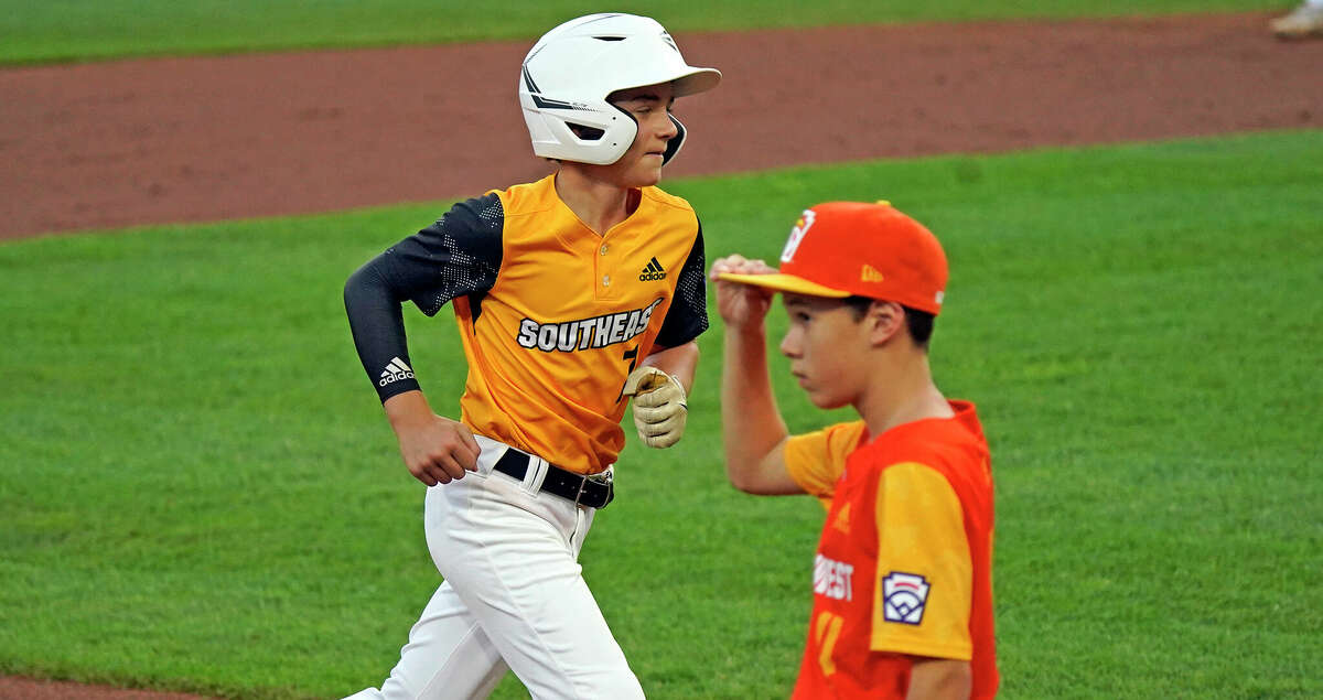 Nolensville, Tenn.'s Josiah Porter, left, rounds third past Pearland, Texas' Malachi Clark after hitting a grand slam during the second inning of a baseball game at the Little League World Series in South Williamsport, Pa., Thursday, Aug. 25, 2022. (AP Photo/Gene J. Puskar)