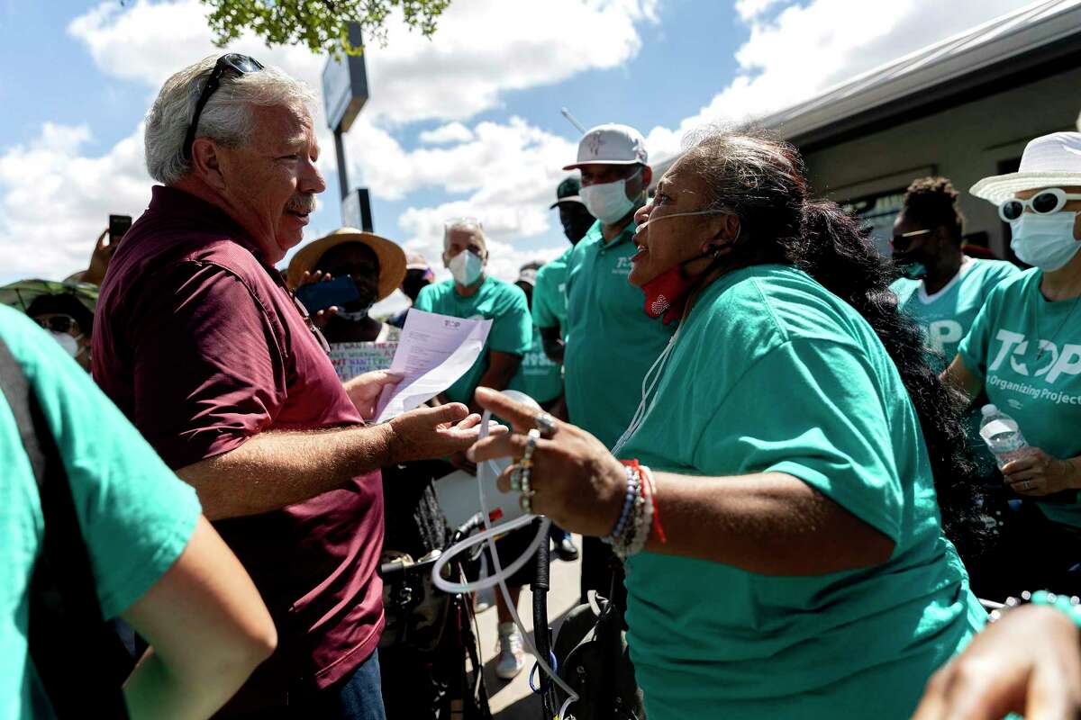 Ernestina Martinez argues with an employee of Achieve Investment Group as she and other Seven Oaks tenants and organizers from the Texas Organizing Project descend on the firm’s Austin office.