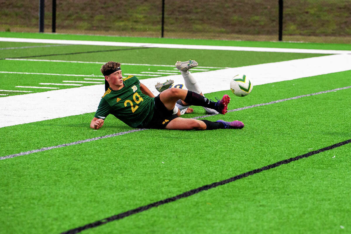 Dow High soccer player Elijah Soderburg slides towards a ball on Aug. 2022 at Dow High School.