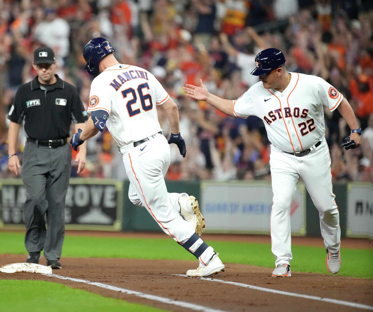 Houston Astros' Trey Mancini (26) rounds first base and first base coach Omar Lopez (22) after he hit a three-run home run against Minnesota Twins starting pitcher Chris Archer during the first inning of an MLB baseball game at Minute Maid Park on Thursday, Aug. 25, 2022 in Houston.