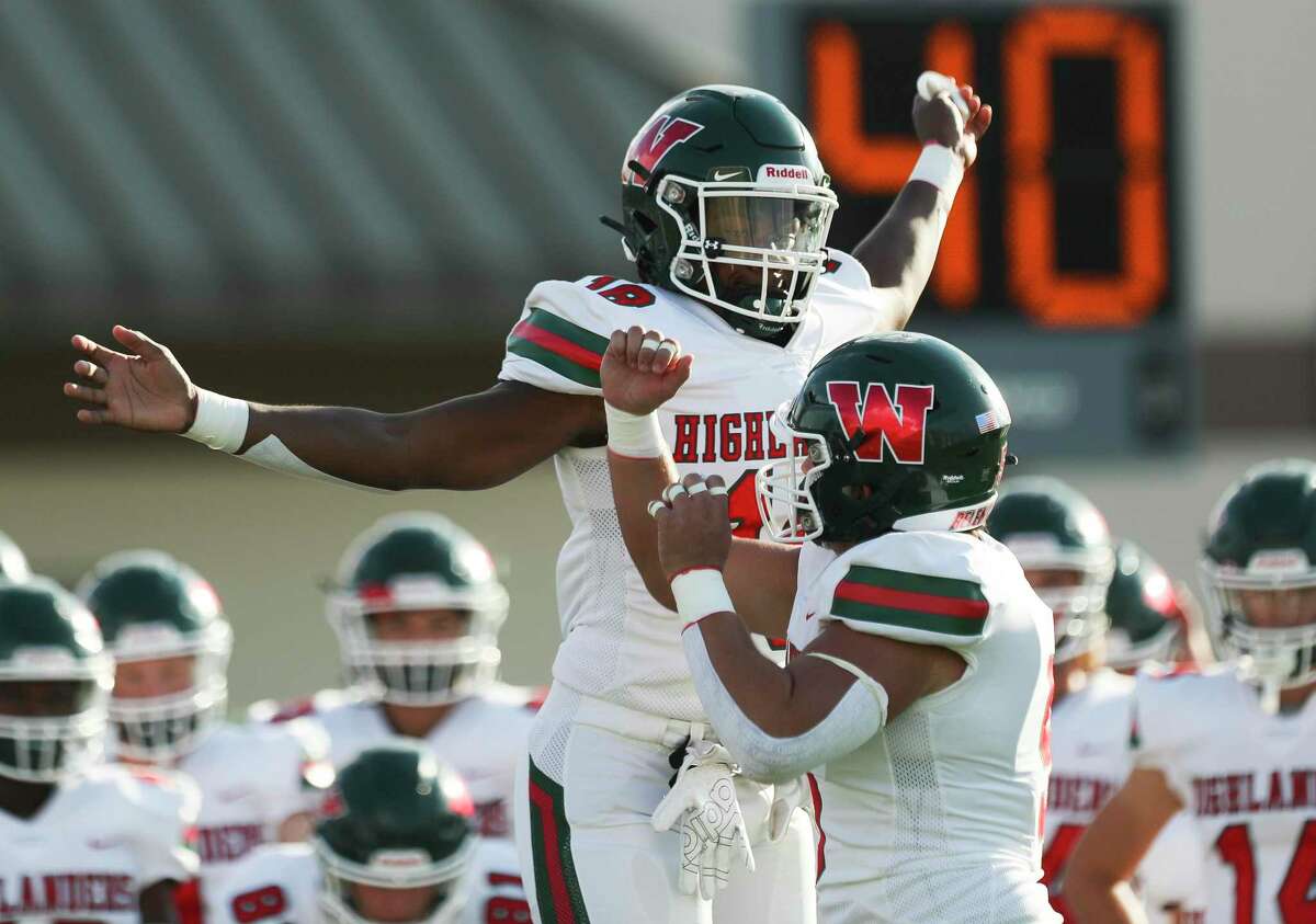 The Woodlands linebacker David Ifeanyi (18) celebrates with linebacker Jacob Pondant (5) before a non-district high school football game at Galena Park ISD Stadium, Thursday, Aug. 25, 2022, in Houston.