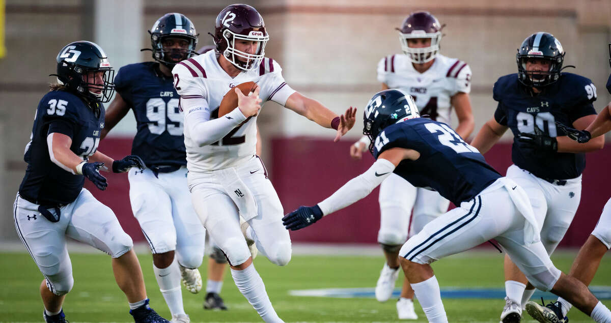 Cinco Ranch quarterback Gavin Rutherford (12) stiff arms College Park defensive back Cole Smith (21) in a high school football game Thursday, Aug 25, 2022, in Shenandoah.