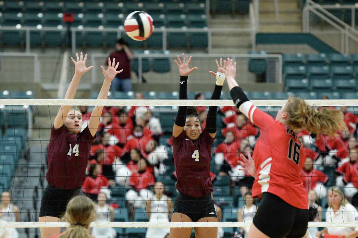 Emily Killam (14) and Gabby Martinez (4) of Cinco Ranch try to block the shot made by Maddie Waak (16) of Katy during the second set of a 6A-III regional quarterfinal playoff match between the Cinco Ranch Cougars and the Katy Tigers on Tuesday, November 9, 2021 at the Leonard Merrell Center, Katy, TX.