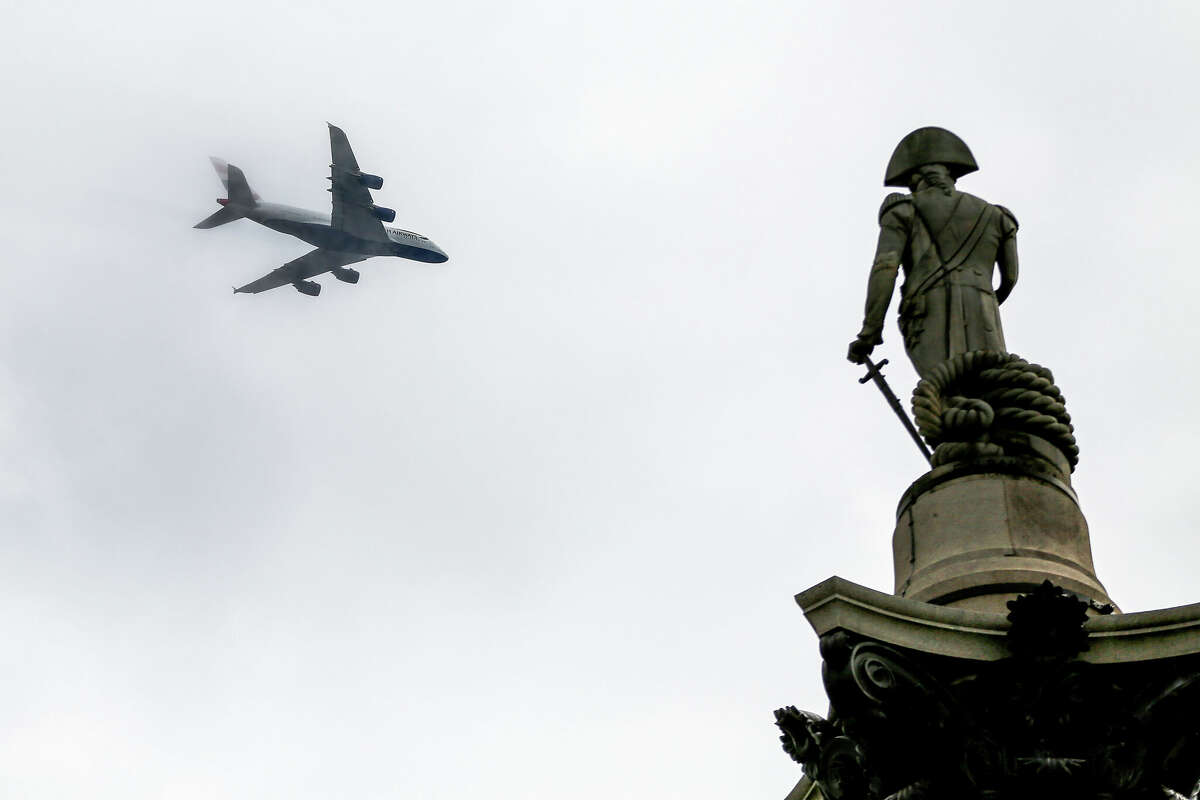 A British Airways A380 aircraft is seen flying through the clouds over Nelson's Column in Trafalgar Square, central London.