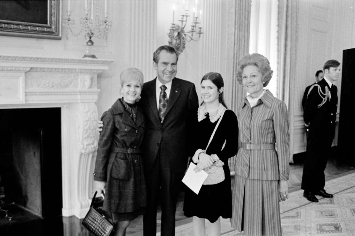 Group portrait of, from left, American actress Debbie Reynolds (1932 - 2016), US President Richard Nixon (1913 - 1994), Reynolds' daughter, actress Carrie Fisher (1956 - 2016), and First Lady Pat Nixon (1912 - 1993) as they pose togather in the White House, Washington DC, February 10, 1974.