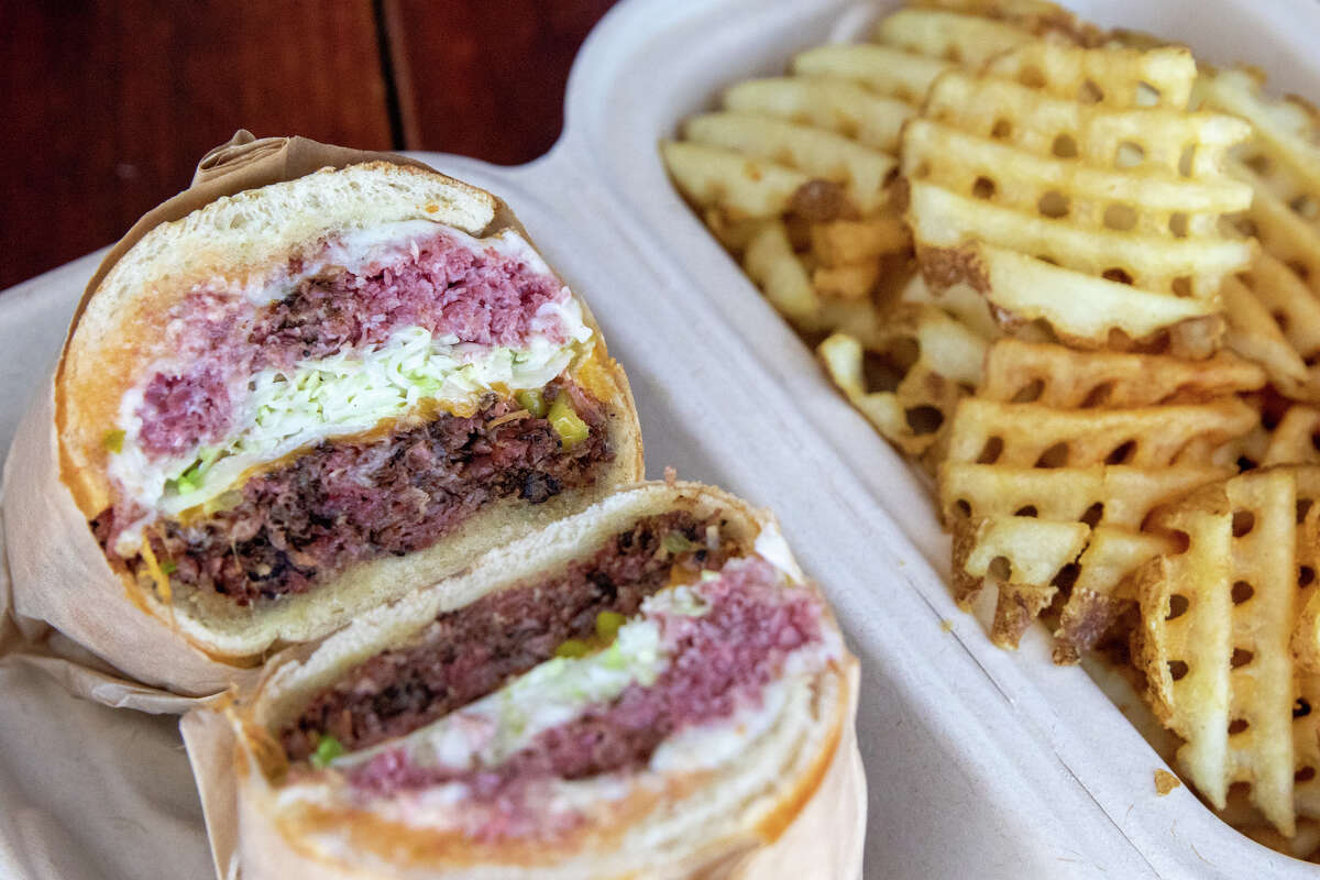The Allison, with pastrami and roast beef, served with a side of waffle fries, is one of the signature sandwiches at Deli Board in San Francisco, Calif. on Aug. 19, 2022.