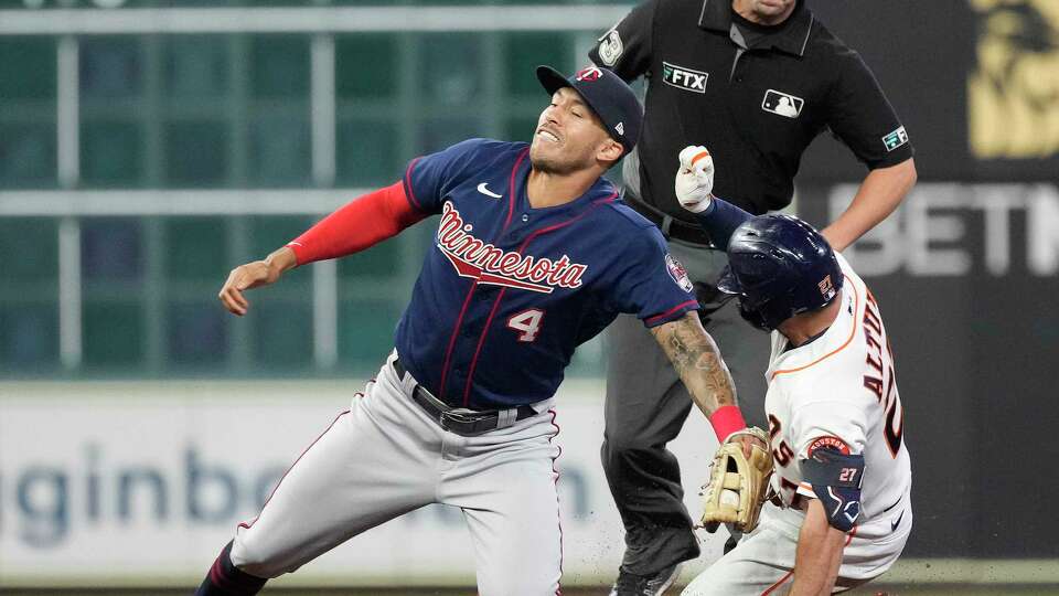 Houston Astros Jose Altuve (27) is tagged out at second base by Minnesota Twins shortstop Carlos Correa (4) after he tried to stretch his single into a double during the third inning of an MLB baseball game at Minute Maid Park on Wednesday, Aug. 24, 2022 in Houston.