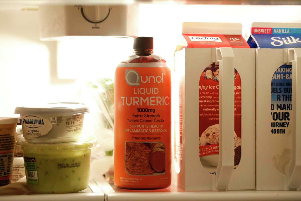 A bottle of liquid tumeric is displayed on a shelf in the refrigerator of Rev. Lily Godsoe on Thursday, August 24, 2022 in Half Moon Bay, Calif. Godsoe got COVID in March 2020 and suffered for more two years with long COVID. Although acupuncture greatly helped many of her symptoms last fall, it wasn't until she bought a large bottle of high-potency turmeric at COSTCO that her most vexing symptom -- deep lung pain -- vanished.