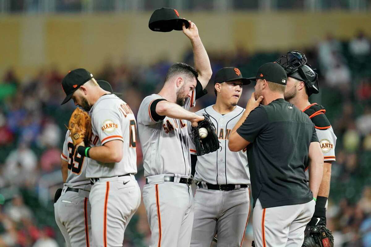 San Francisco Giants starting pitcher Alex Wood, middle, reacts as pitching coach Andrew Bailey, second right, comes to the mound during the third inning of a baseball game against the Minnesota Twins Friday, Aug. 26, 2022, in Minneapolis. (AP Photo/Abbie Parr)
