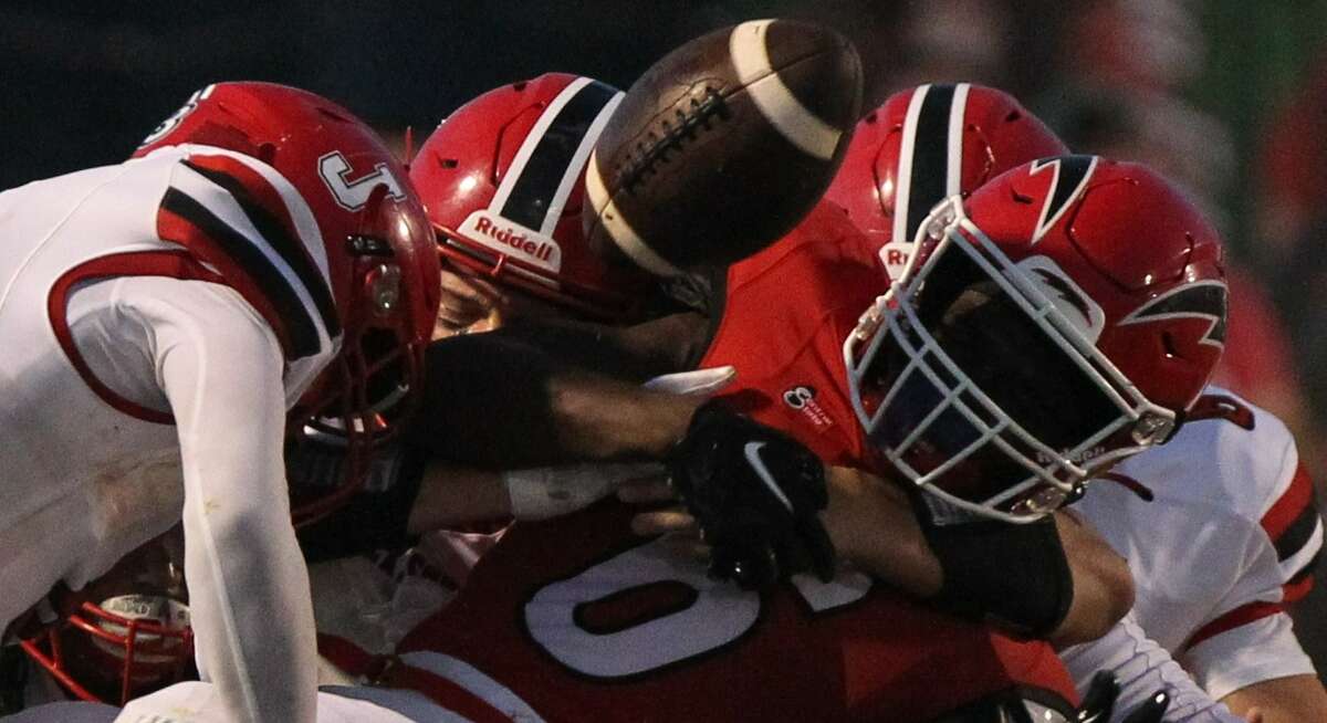 Jacksonville's defense pries the ball loose from a Glenwood ball carrier during a football game at Chatham Friday night.