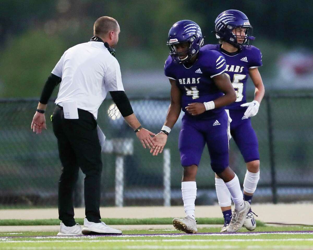 Montgomery quarterback Reggie Williams (4) gets a low-five from head coach Grant Cooper after running for a 5-yard touchdown in the first quarter of a non-district high school football game at MISD Stadium, Friday, Aug. 26, 2022, in Montgomery.