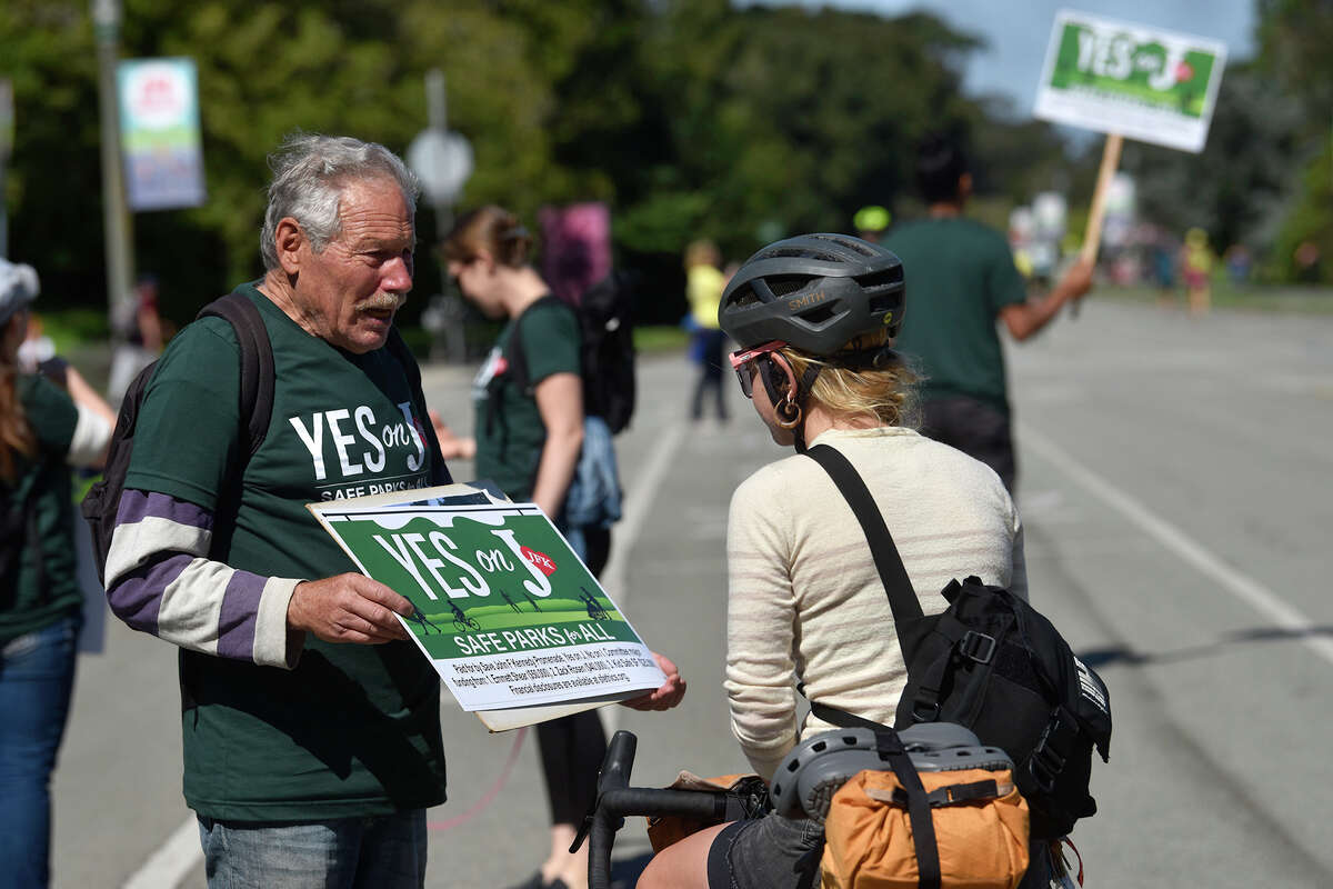 Greg Gaar, a proponent of Proposition J, speaks with a passing cyclist about the implications of the upcoming ballot measure, which seeks to keep JFK Drive free of car traffic. 