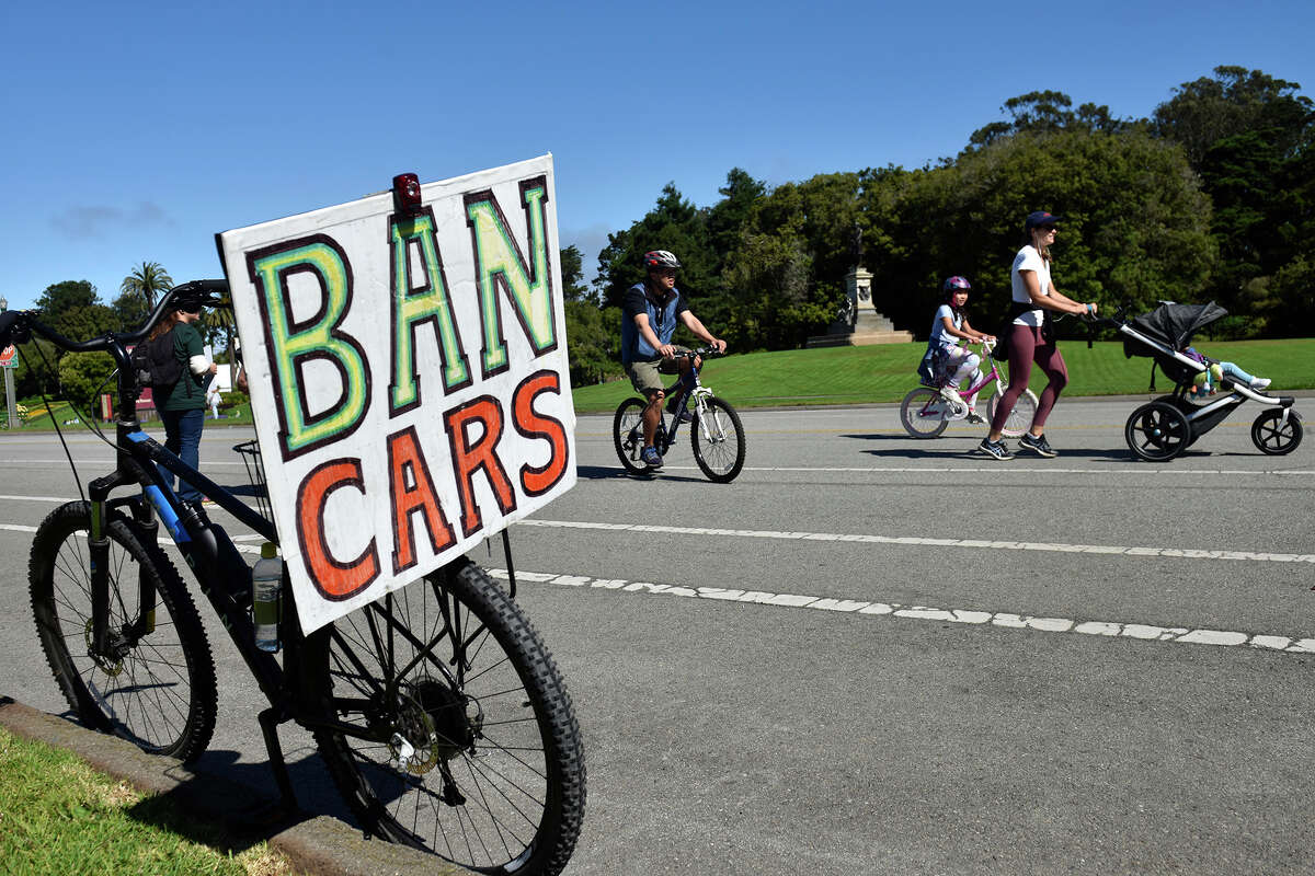A sign reading "Ban Cars" hangs from the back of a bicycle during a Proposition J rally in Golden Gate Park, on Saturday, Aug. 27, 2022. 