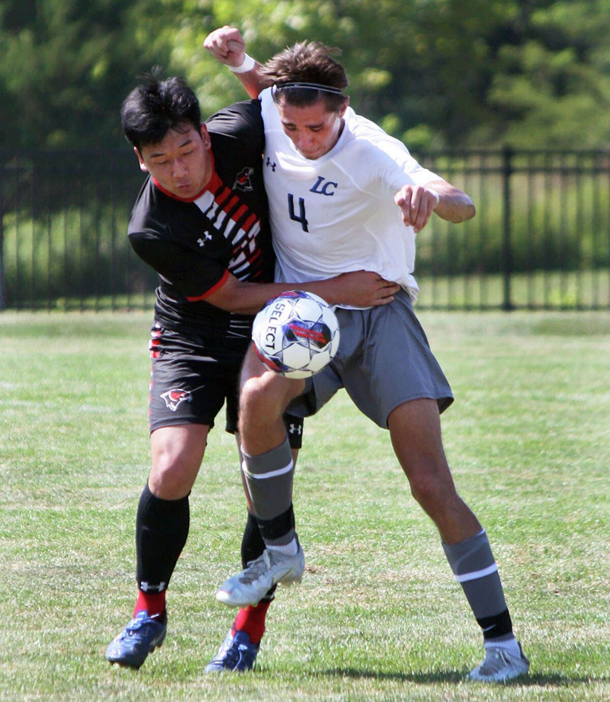 LCCC's Gino Buffa (4) a sophomore from Howell Central High School, battles for the ball with a Southeastern College player Saturday at Tim Rooney Field.
