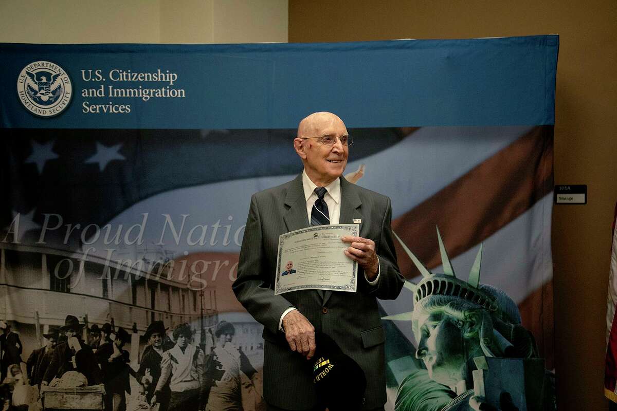 Heinz Bachman holds his citizenship certificate after being sworn in as a naturalized U.S. citizen in 2021. Bachman, one of just two surviving Pearl Harbor veterans in the San Antonio area, died Saturday at age 100.