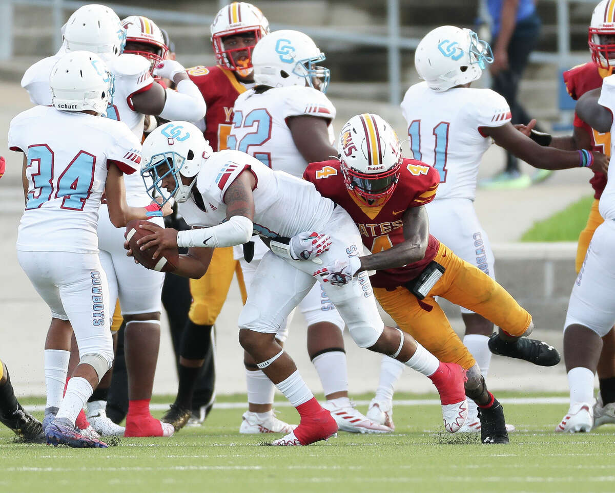 Yates defensive back Marquise Sattiewhite (4) tackles Dallas Yates place holder Jemelh Chambers (4) to stop an extra point during the second quarter of a non-district high school football game at Delmar Stadium, Saturday, Aug. 27, 2022, in Houston.