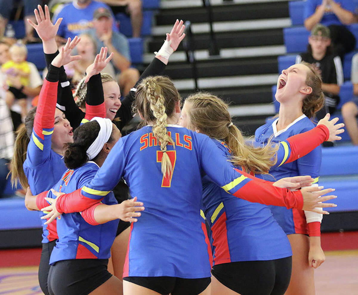 Roxana's Lily Daugherty (right) celebrates a point with teammates Genna Pruett (left), Kaylyn Dixon (left back), C.J. Ross (left front), Peyton Petit (7) and Destiny Vuylsteke in their title-match victory over Valmeyer on Saturday at the 13th annual Roxana Invitational girls volleyball tournament,