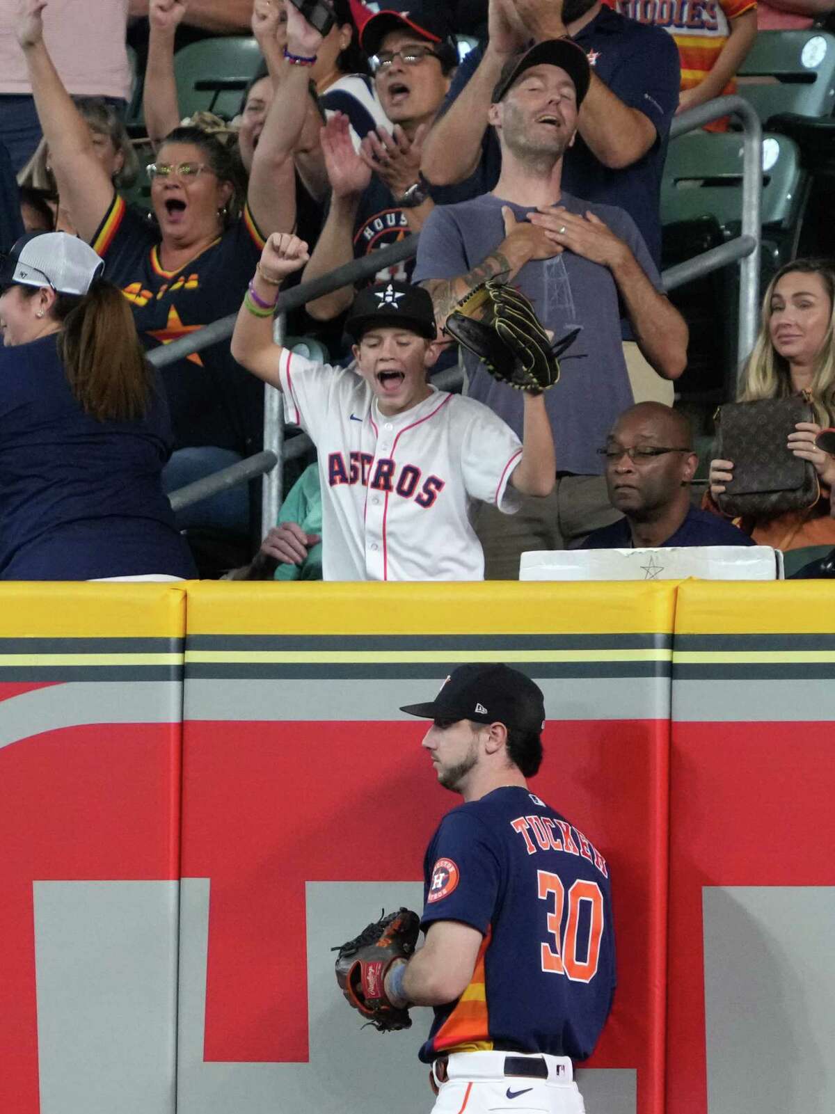 Houston Astros fans react after right fielder Kyle Tucker (30) caught a deep fly ball in right hit by Baltimore Orioles third baseman Ramon Urias during the first inning of a Major League Baseball game on Sunday, Aug. 28, 2022, in Houston.
