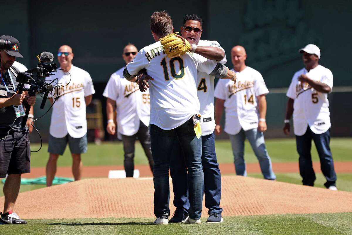 Oakland Athletics’ Miguel Tejada hugs Scott Hatteberg during ceremony honoring 20 game win streak by 2002 A’s before MLB game at Oakland Coliseum in Oakland, Calif., on Sunday, August 28, 2022.