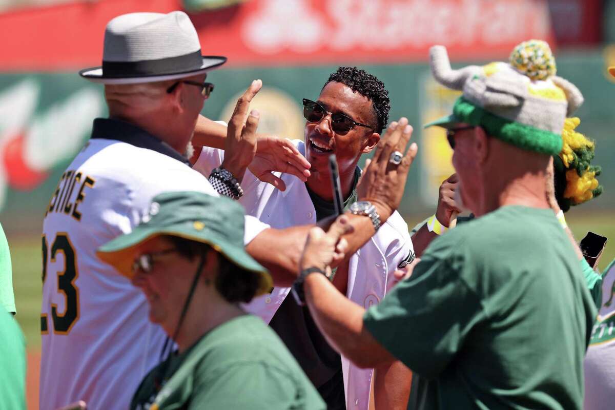 Oakland Athletics’ David Justice greets a line of fans during ceremony honoring 20 game win streak by 2002 A’s before MLB game at Oakland Coliseum in Oakland, Calif., on Sunday, August 28, 2022.