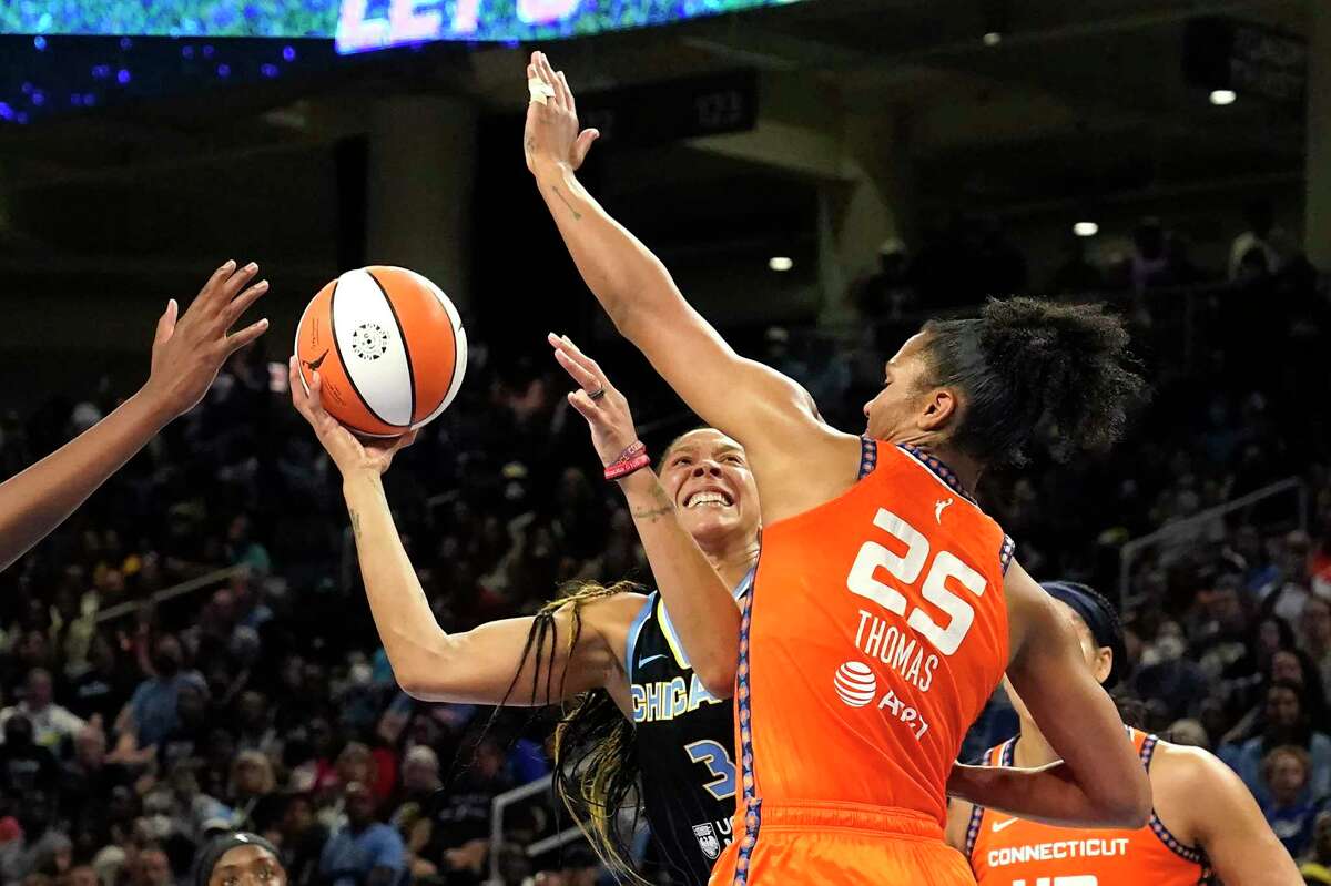 Chicago Sky's Candace Parker shoots under pressure from Connecticut Sun's Alyssa Thomas during the second half in Game 1 of a WNBA basketball semifinal playoff series Sunday, Aug. 28, 2022, in Chicago. The Sun won 68-63. (AP Photo/Charles Rex Arbogast)