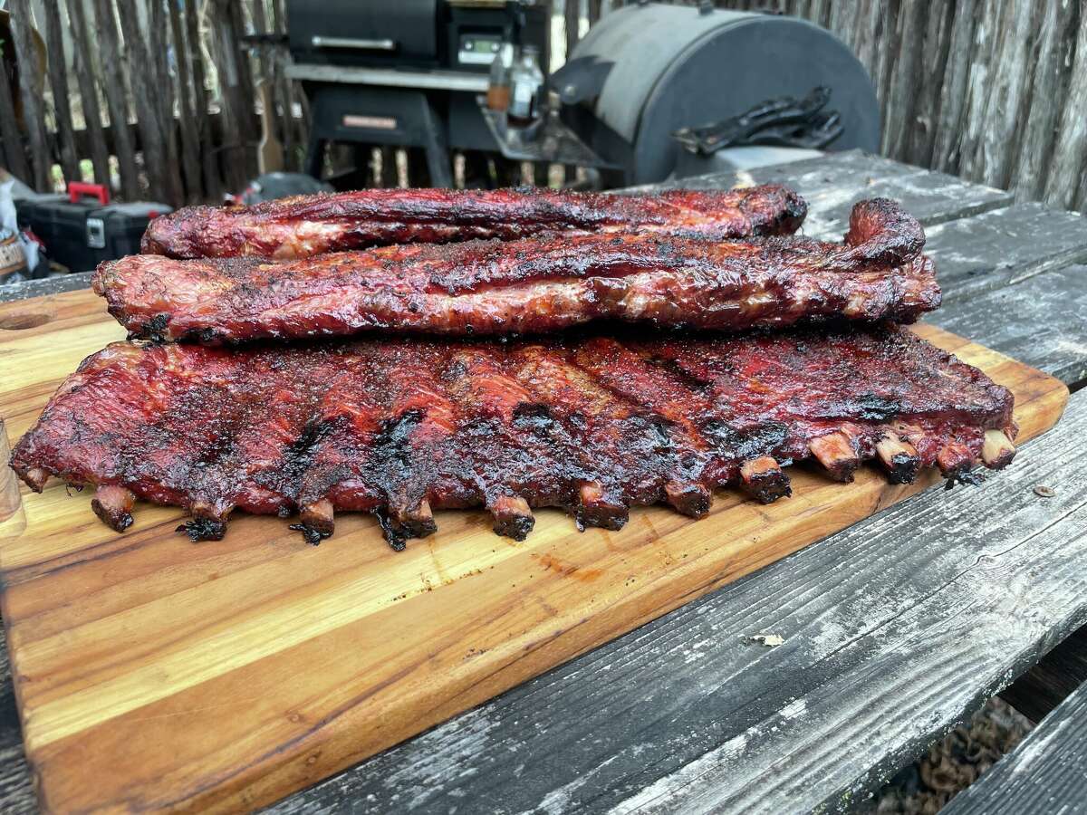 An assortment of finished pork spare ribs cooked with a combination of pecan and oak wood with the membrane treated in three different ways.