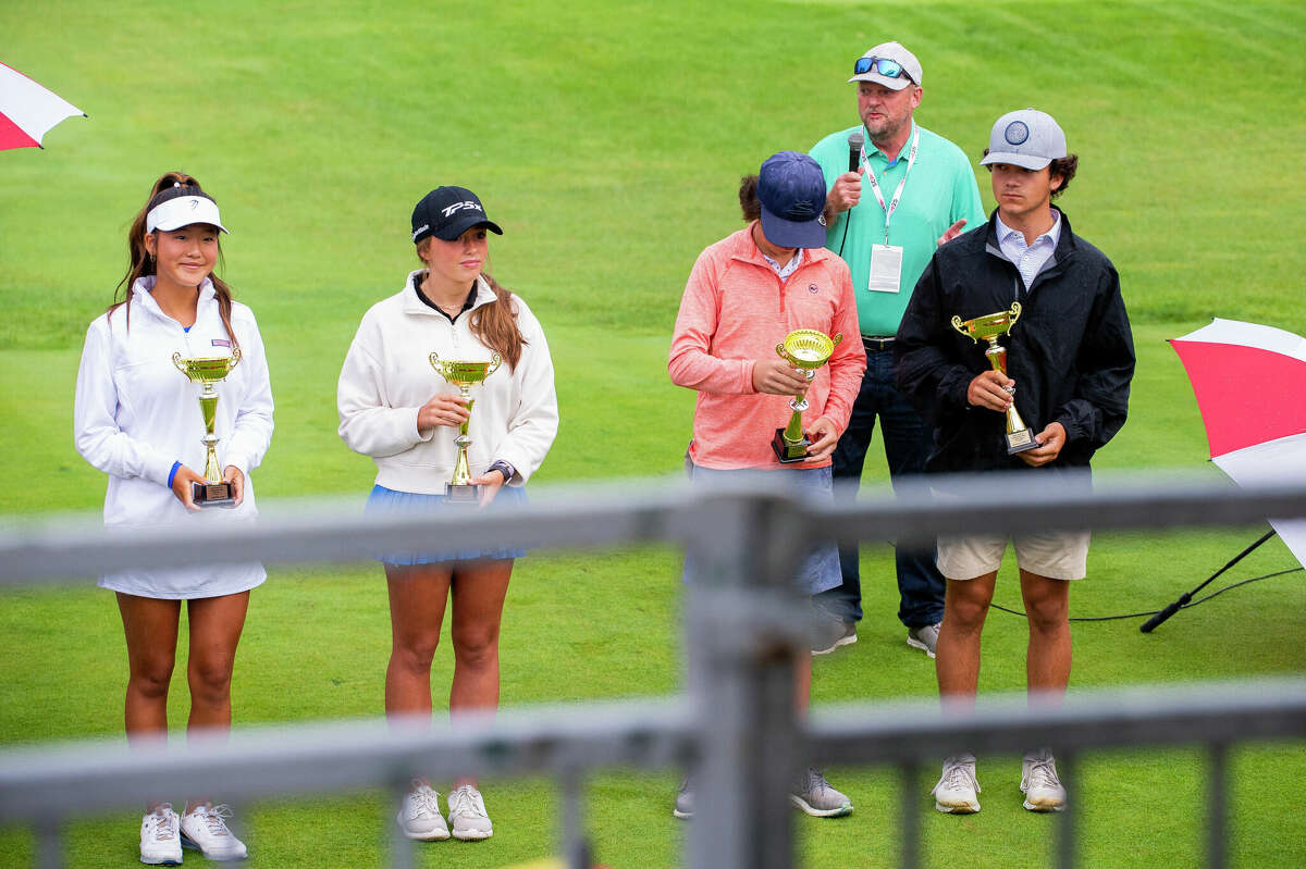 Dow High freshman Sophia Lee (far left) poses with her Great Lakes Bay Junior Golf Championship trophy during the opening ceremony for the Dow Great Lakes Bay Invitational at Midland Country Club on July 13, 2022. Lee shot a 78 recently to win individual medalist honors at the Frank Altimore Invitational held at Currie Golf Course.  