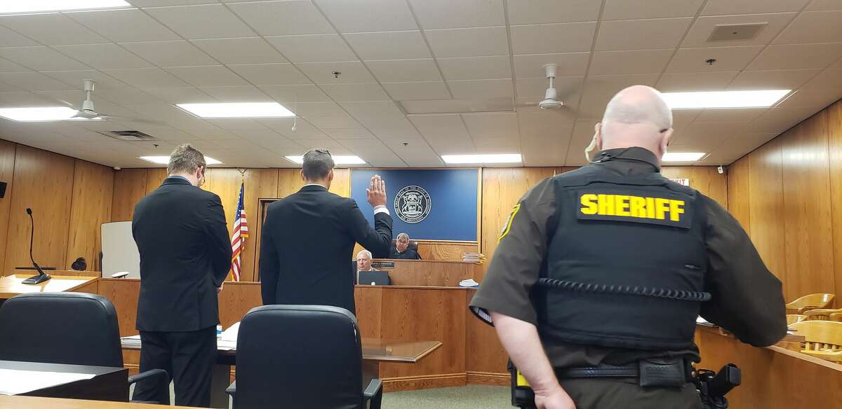 Israel Jordan Ankerson (center) raises his hand as instructed by Judge David Thompson before pleading guilty to several charges during a plea agreement on Monday at Manistee County's 19th Circuit Court.