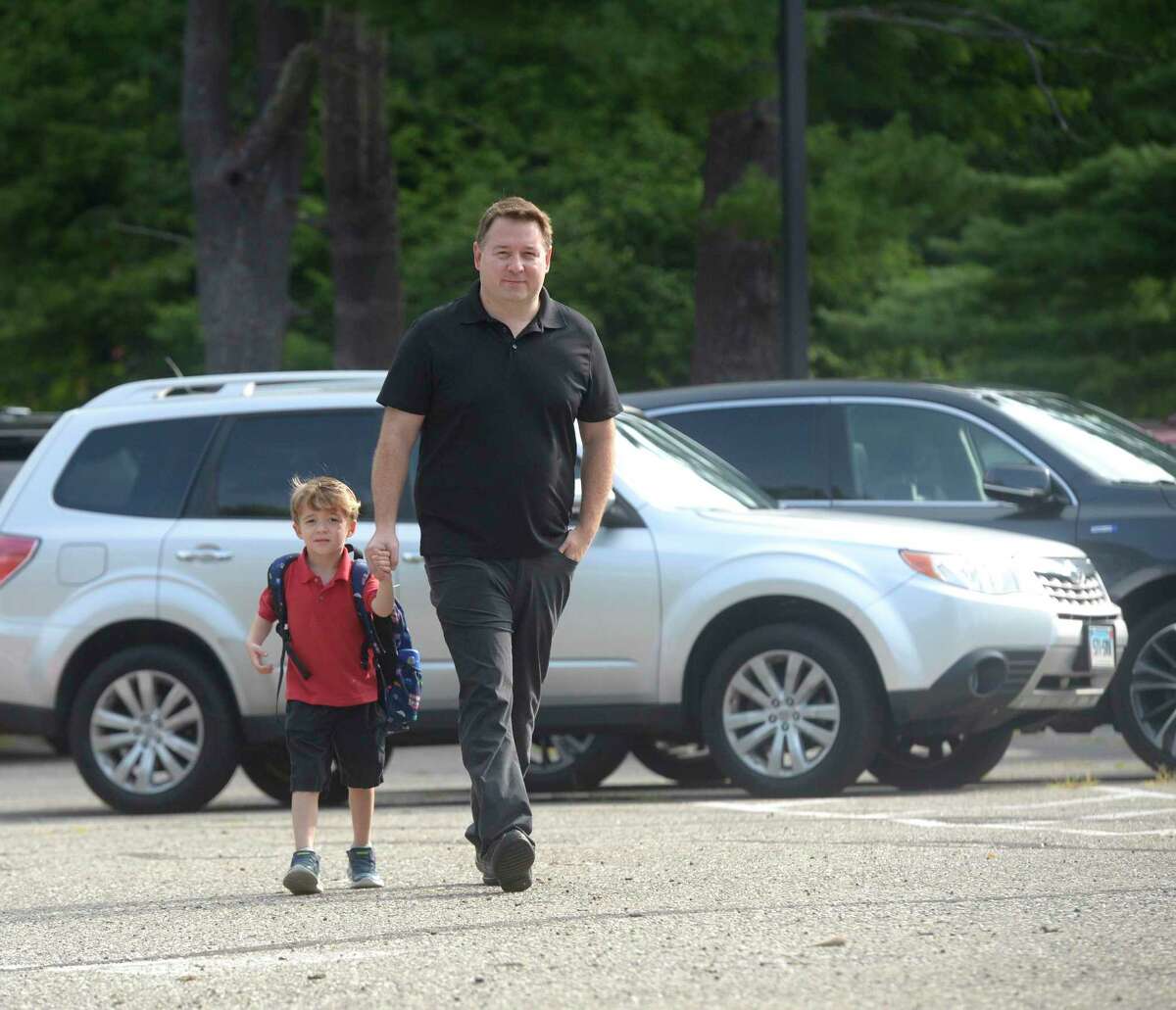 Adrian Raider, age 5, walks with his father Mark to his first day of kindergarten at Farmingville Elementary School, Ridgefield, Conn. Monday morning, August 29, 2022.