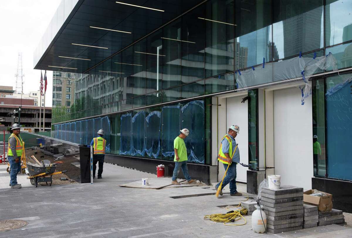 Workers working on the front entrance of Harris County Criminal Justice Center Monday, Aug. 22, 2022, in Houston. Different flood barrier systems are installed around the building. The front has two vertical flood gates and flood resistant glasses. The building has been undergone restoration and renovation after Hurricane Harvey, when everything was flooded and damaged by burst pipes.