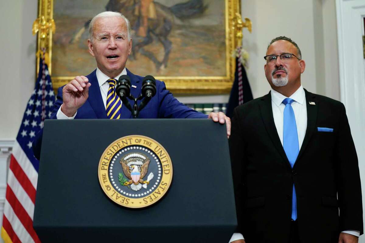 President Joe Biden, flanked by Education Secretary Miguel Cardona, outlines his student loan forgiveness program.