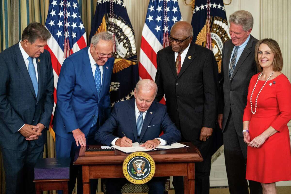 President Joe Biden, flanked by, from left, Sen. Joe Manchin (D-WV), Senate Majority Leader Chuck Schumer (D-NY), House Majority Whip Jim Clyburn (D-SC), Rep. Frank Pallone (D-NJ), and Rep. Kathy Castor (D-FL), delivers remarks and signs the Inflation Reduction Act of 2022 into law in the State Dining Room of the White House on Tuesday, Aug. 16, 2022, in Washington, D.C. (Kent Nishimura/Los Angeles Times/TNS)