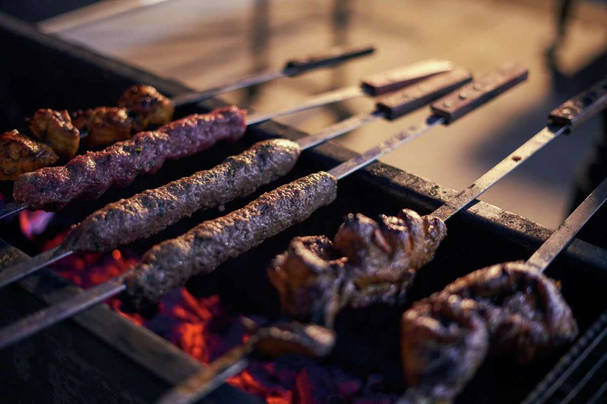 Skewers cook on the embers outside chef Ron Dumra's restaurant, Wah Jee Wah in Hayward.