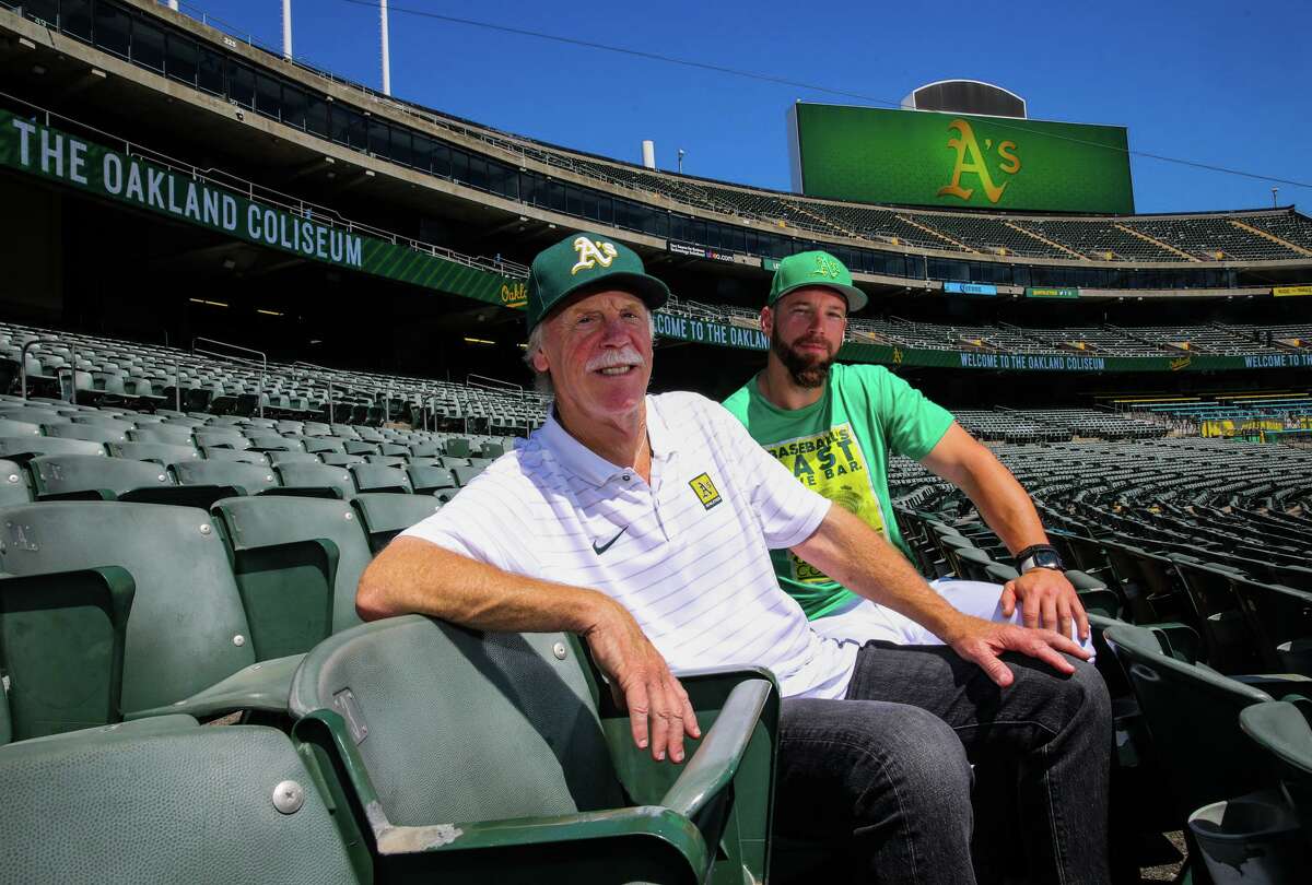 Oakland Athletics bullpen catcher Dustin Hughes, 39, and his father John Hughes, 70, a scout, pose during a portrait session at the Oakland Coliseum on Saturday, Aug. 20, 2022.