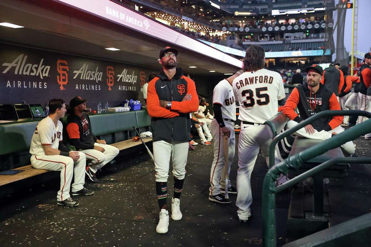 San Francisco Giants’ manager Gabe Kapler and players wait out a delay for dim lighting during MLB game against San Diego Padres at Oracle Park in San Francisco, Calif., on Monday, August 29, 2022.