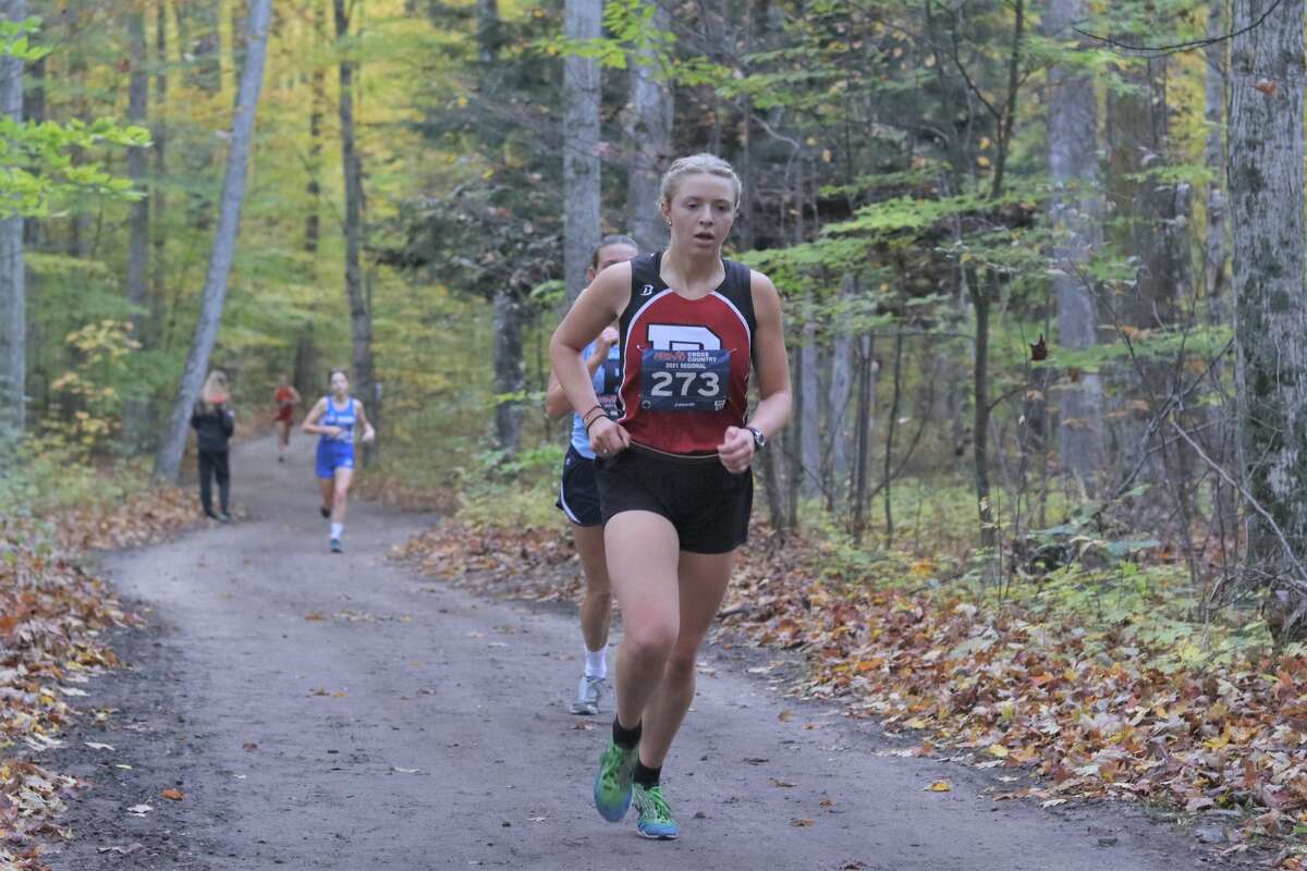 Lillian Mauntler races through the woods during cross country regionals at Benzie Central last season. 