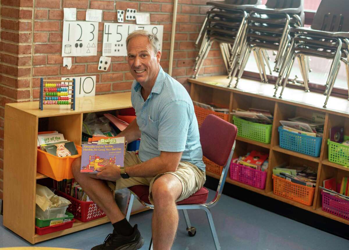 Parkway School kindergarten teacher Patrick Sweeney pulls books out of colorful bins in his classroom Monday, August 29, 2022.