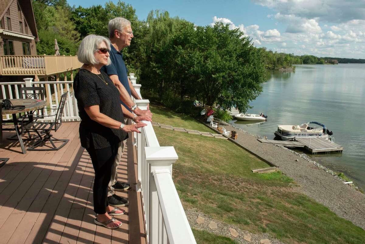 Al Kaplan and his wife Janet Kaplan stand on their friend’s deck which overlooks Sleepy Hollow Lake on Wednesday, Aug. 24, 2022 in Athens, N.Y.