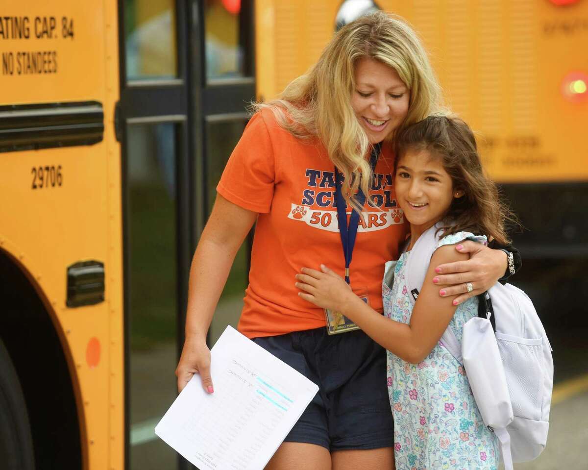 Speech pathologist Kaelyn Bonaventura shares a hug with a returning student during first day of school at Tashua Elementary School in Trumbull, Conn. on Tuesday, August 30, 2022.