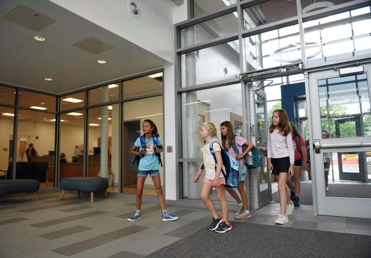 Students enter the new Ox Ridge Elementary School in Darien, Conn. Tuesday, Aug. 30, 2022. Students were welcomed this week to the brand new Ox Ridge Elementary School, a two-year, $50 million project that features a modernized building with interconnecting common learning spaces between clusters of classrooms and a courtyard.